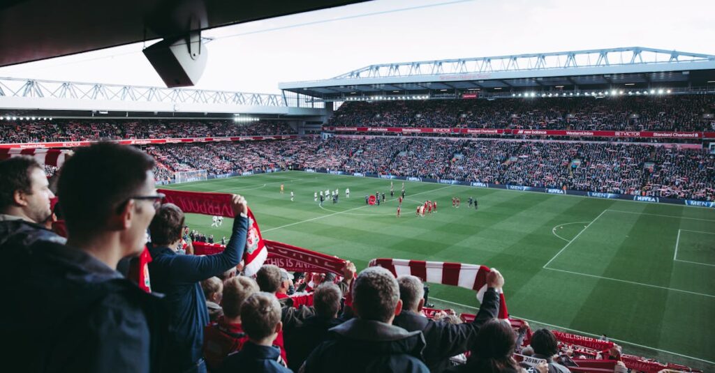 Fans cheer as players take the field at a vibrant football stadium, creating an electric atmosphere.