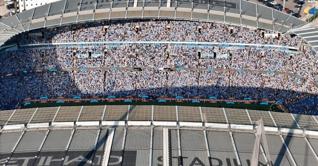 Aerial shot of Etihad Stadium filled with soccer fans in Manchester, UK.